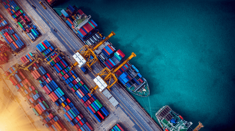 A vibrant container port with colourful shipping containers and large cranes, showcasing the efficiency and scale of global trade and maritime logistics.