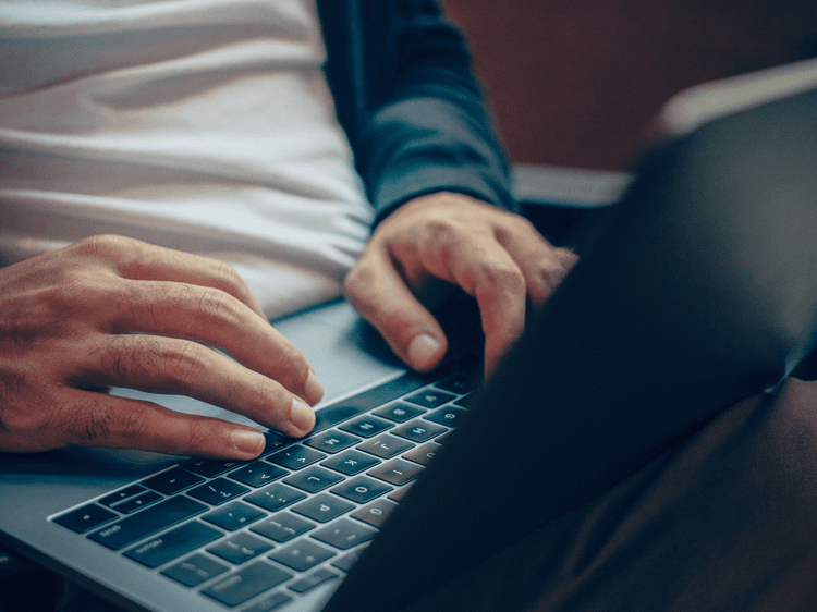 person typing on a laptop keyboard