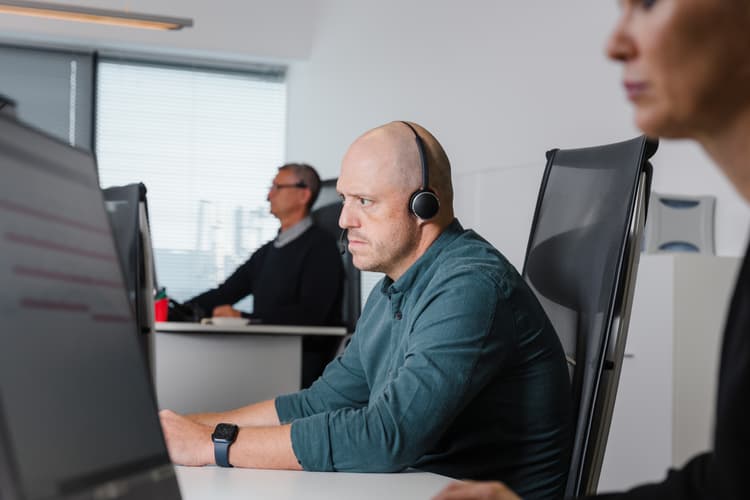 Professionals working in a control room, monitoring operations and providing real-time support