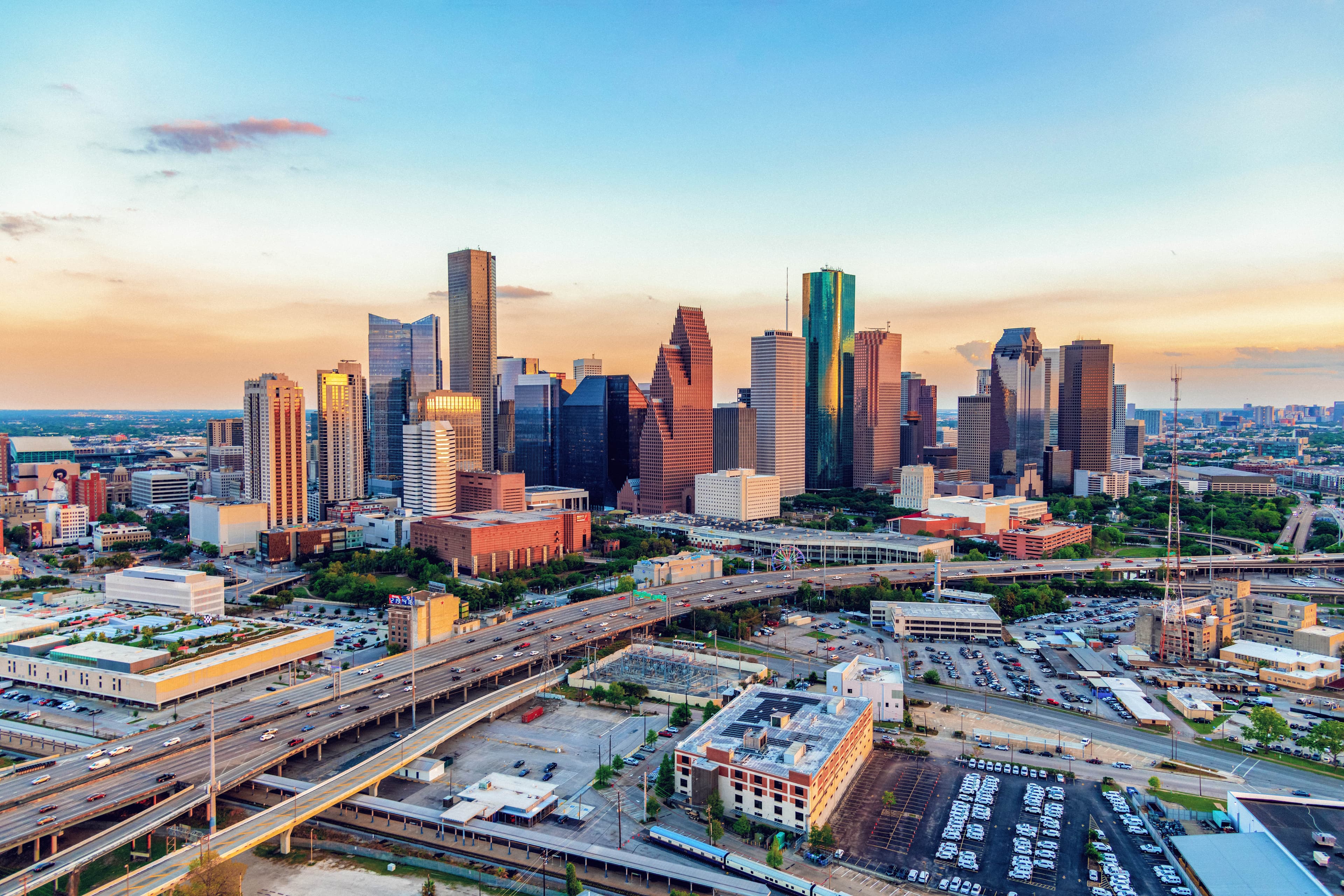 A stunning view of downtown Houston at sunset, showcasing the city’s iconic skyline with its mix of modern skyscrapers and vibrant urban landscape.