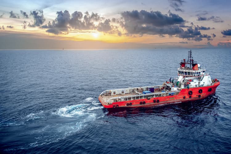 A supply boat delivering essential equipment, supporting vital operations at sea.