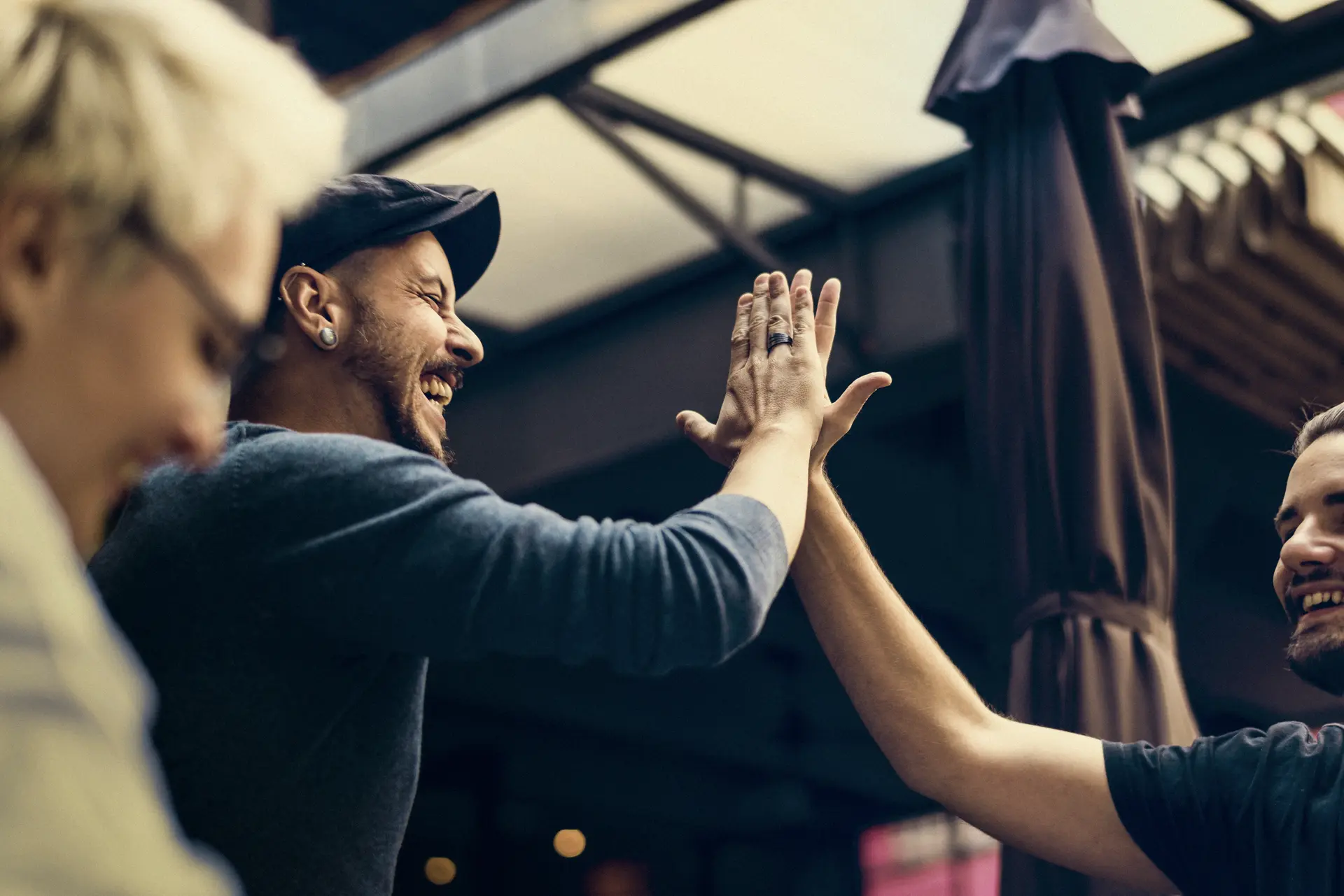 two colleagues sharing a high-five, both smiling and expressing a sense of camaraderie and achievement.